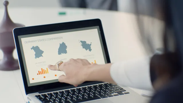 A woman pointing at a laptop screen showing a state comparison chart at a business desk. Branschkartor i Sverige: så kartlägger du en näringsgren med SNI och offentlig statistik